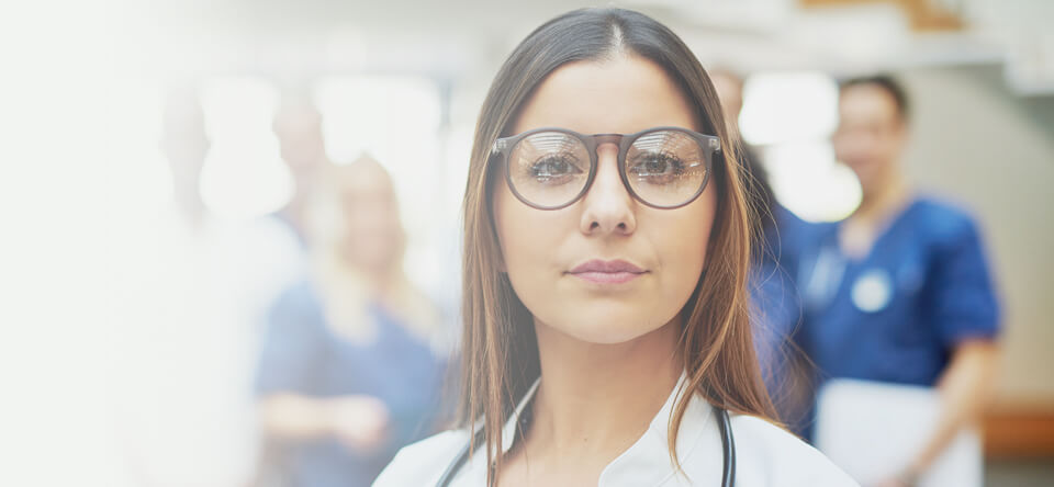 Medical professional with glasses looking at the camera